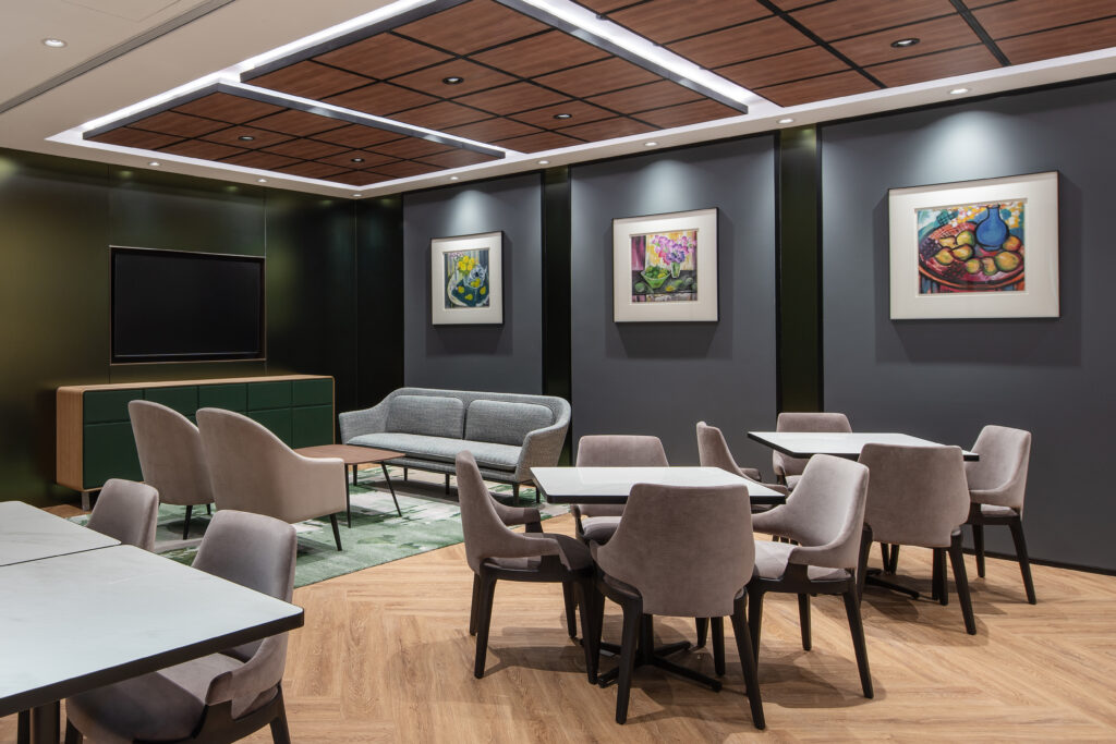 A lounge-type interior fit-out for a coworking space featuring accent lights over artwork