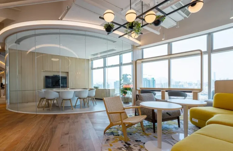 Modern sustainable office renovation featuring energy-efficient glass walls, natural wood flooring, and ergonomic furniture designed by a professional office renovation company, Legend Interiors.