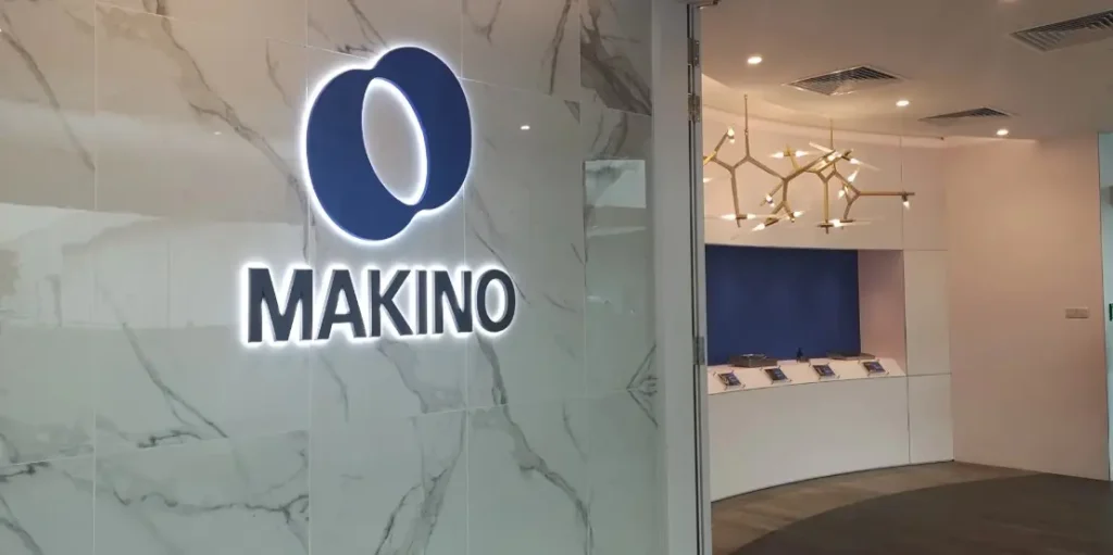 Makino's office facade. A led-lined Makino logo against a marble wall.