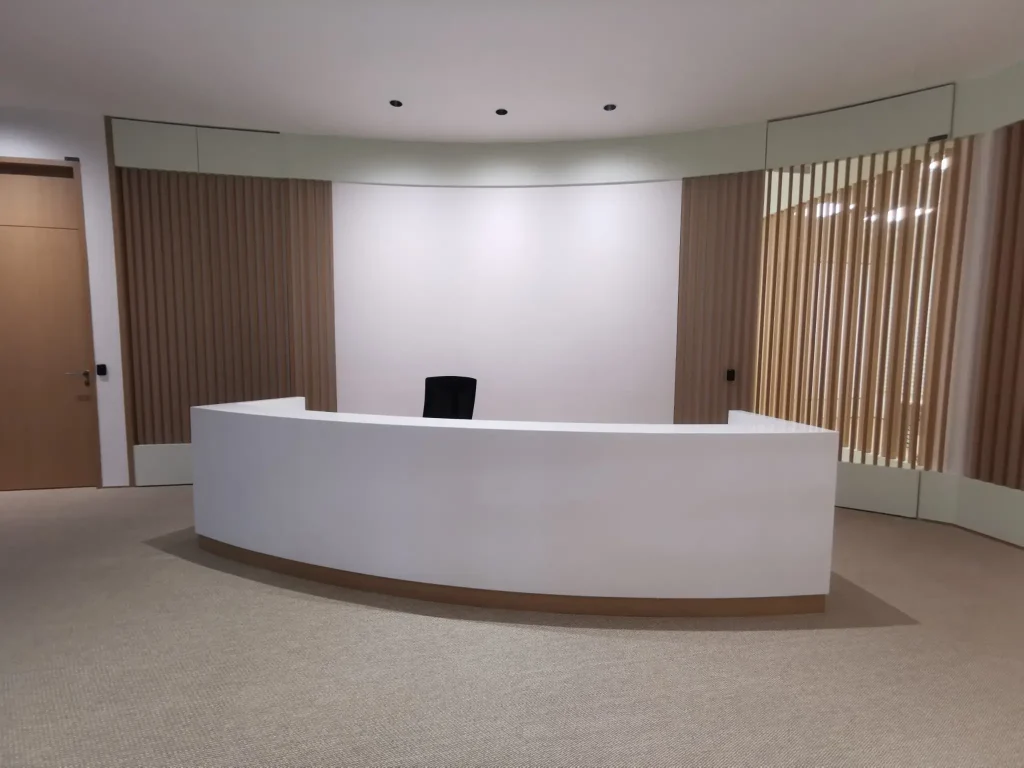 A sleek, white reception desk against brown walls
